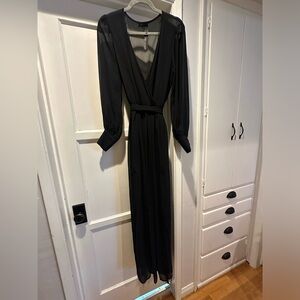 Long sleeved, sheet black maxi dress with belt.